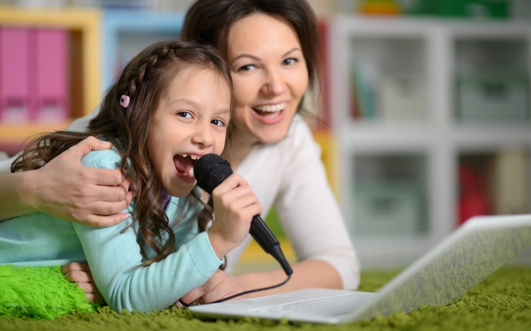Mother and daughter looking at laptop computer singing karaoke